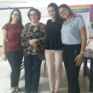 Quatro pessoas de pé sorrindo para fotografia