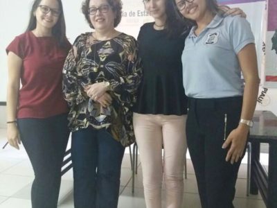 Quatro pessoas de pé sorrindo para fotografia