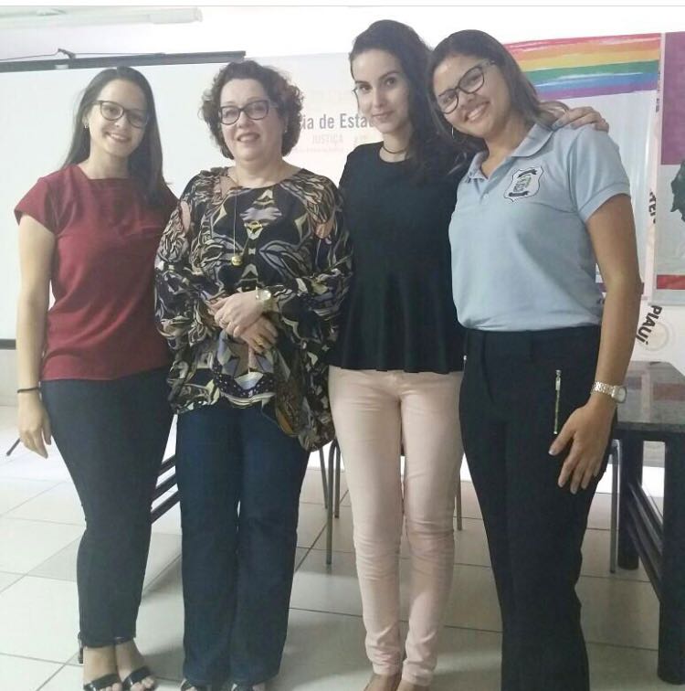 Quatro pessoas de pé sorrindo para fotografia