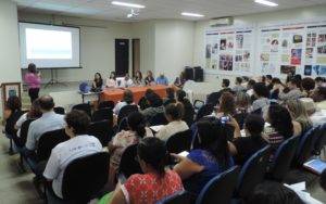 Pessoas sentadas em auditório assistindo palestra