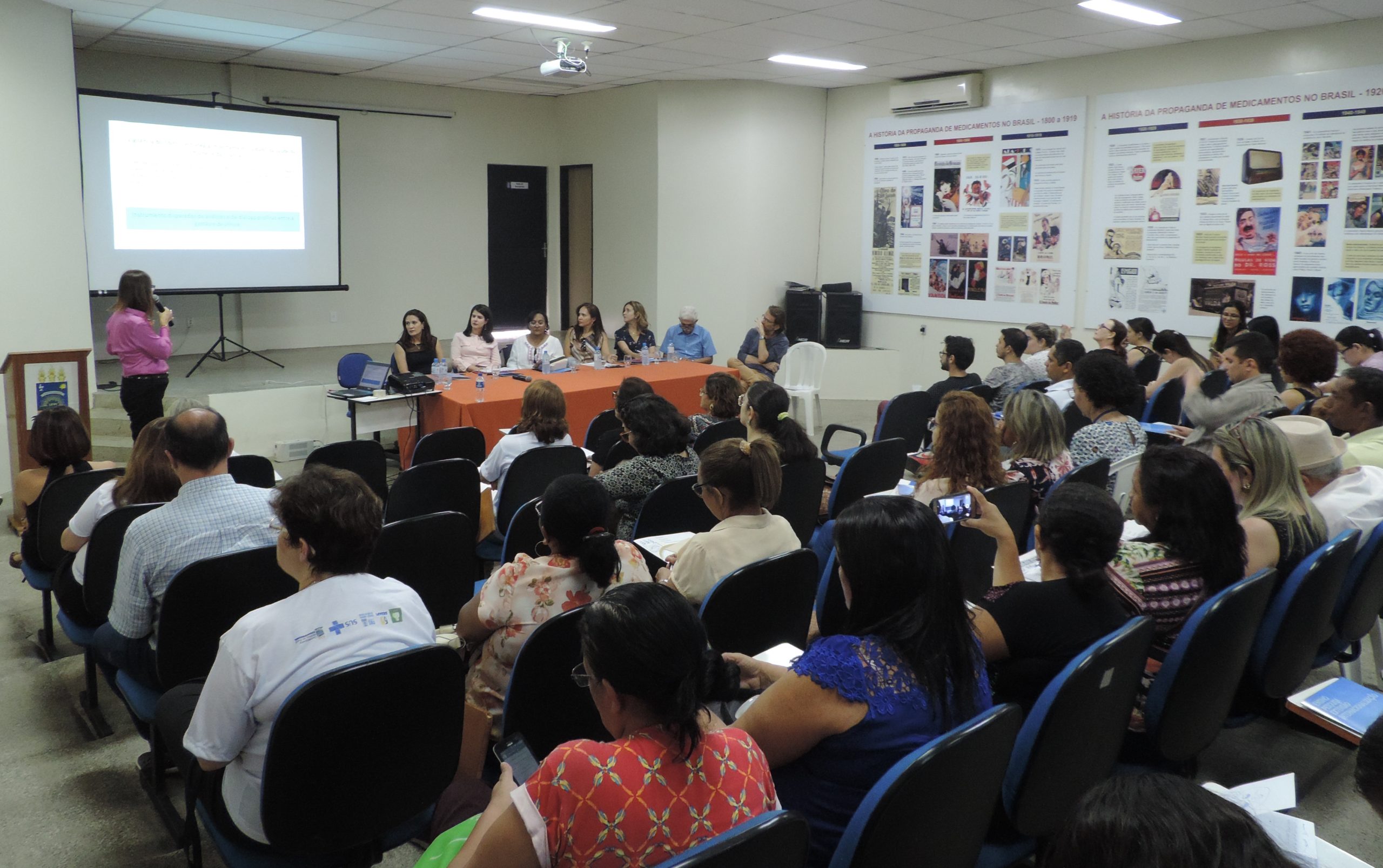 Pessoas sentadas em auditório assistindo palestra
