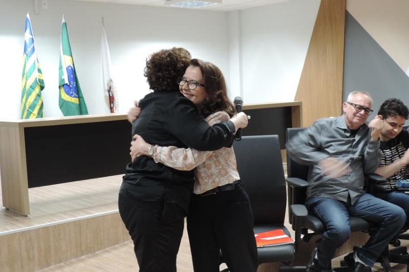 Duas pessoas de pé se abraçando