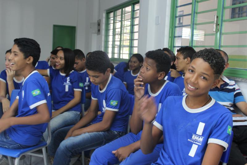 Adolescentes e jovens sentados numa sala de aula assistindo uma palestra 