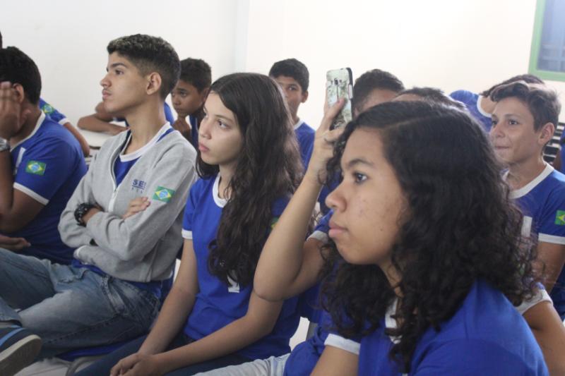 Adolescentes e jovens sentados assistindo uma palestra 