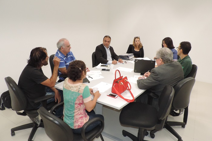 Pessoas sentadas em volta de uma mesa conversando umas com as outras