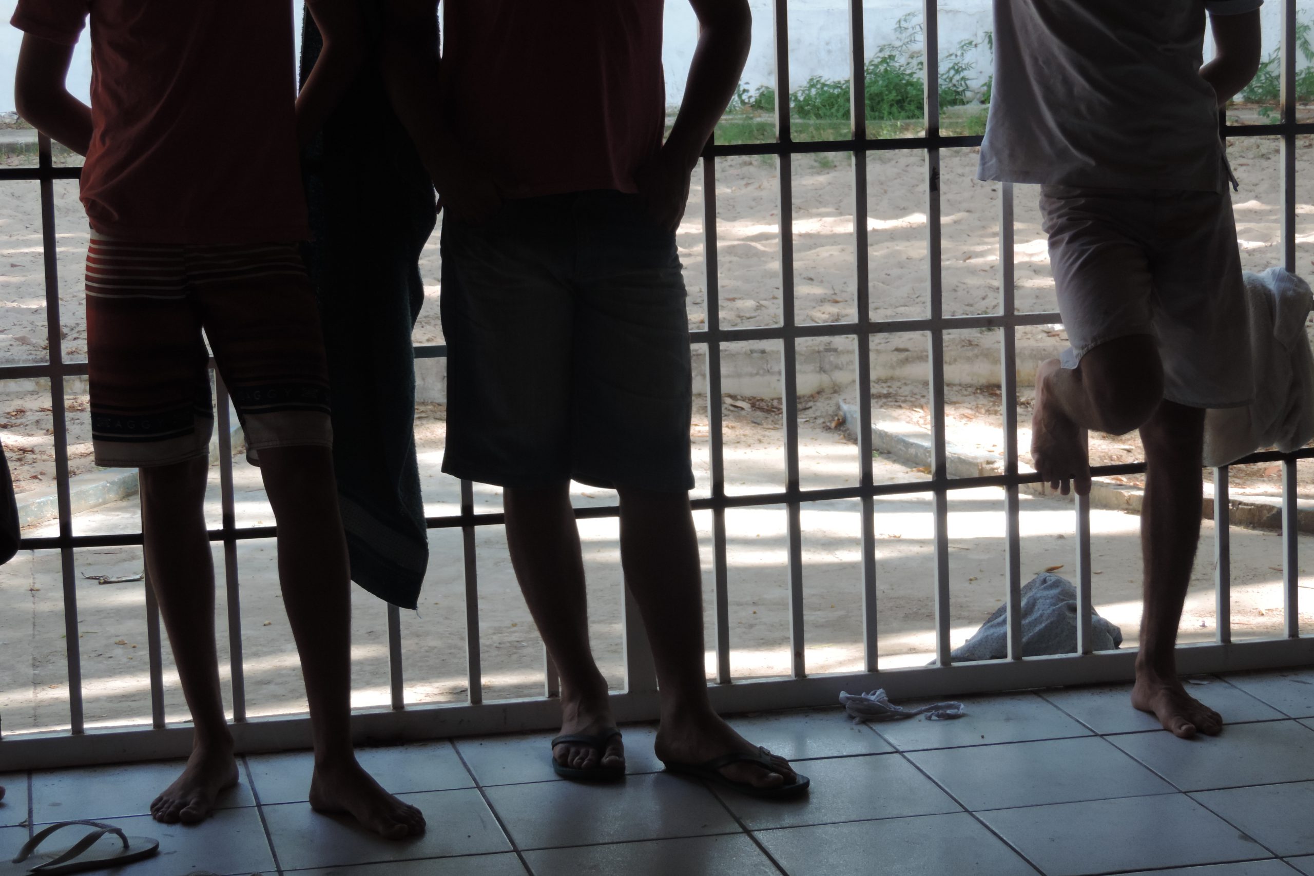 Pessoas de pé encostadas na grade 
