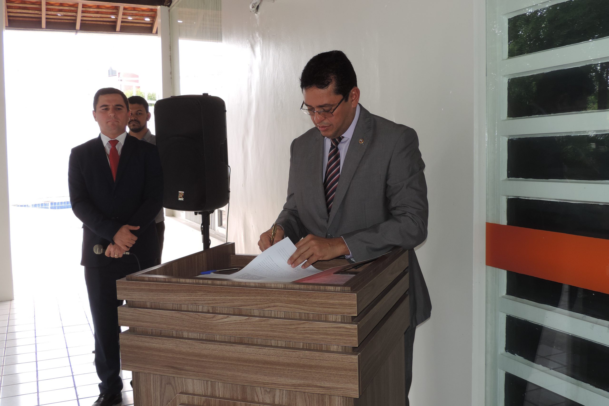 Pessoa de pé assinando documento 