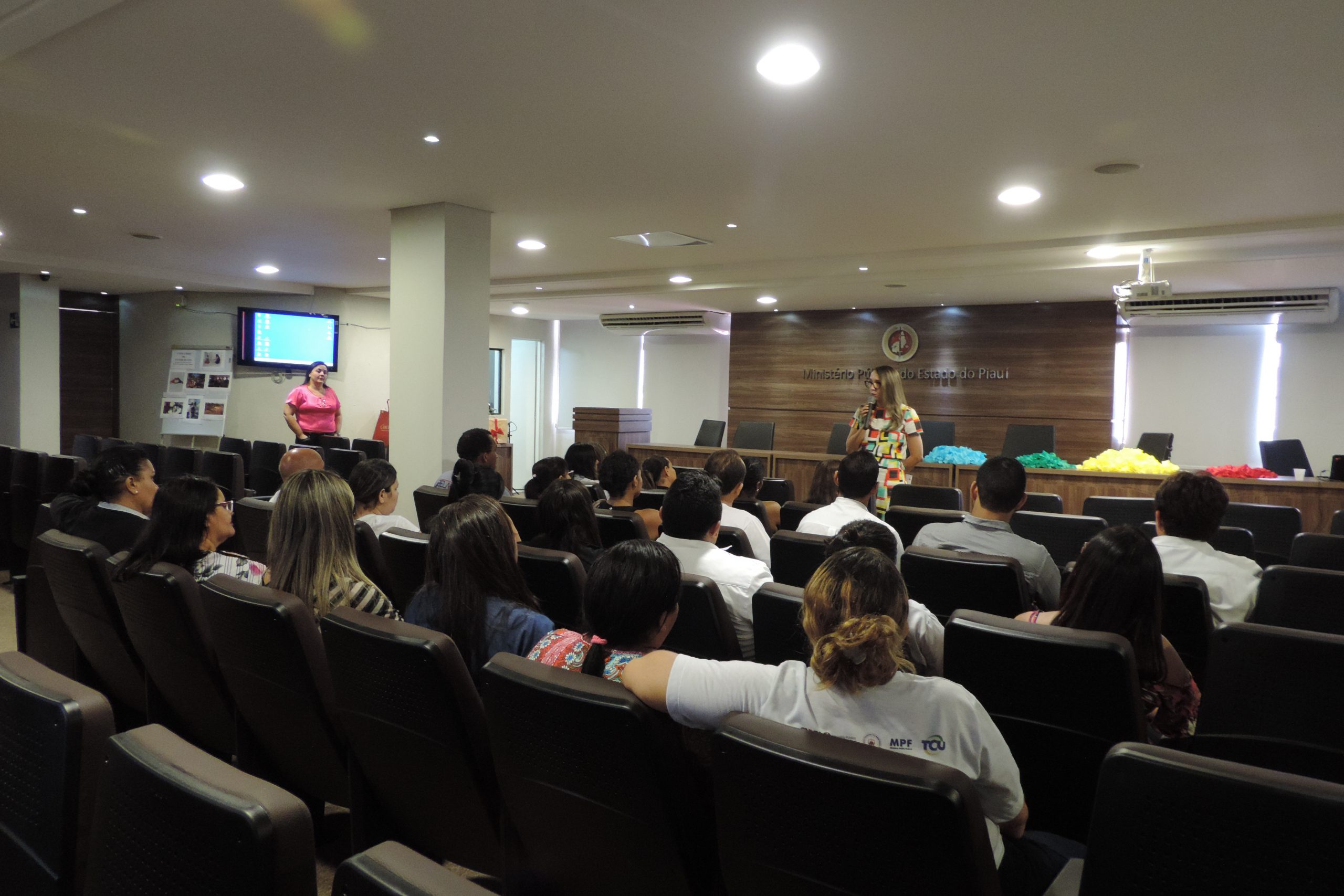 Pessoas sentadas em auditório 