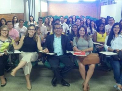 Pessoas sentadas em sala de aula e sorrindo para a pessoa que faz a fotografia delas