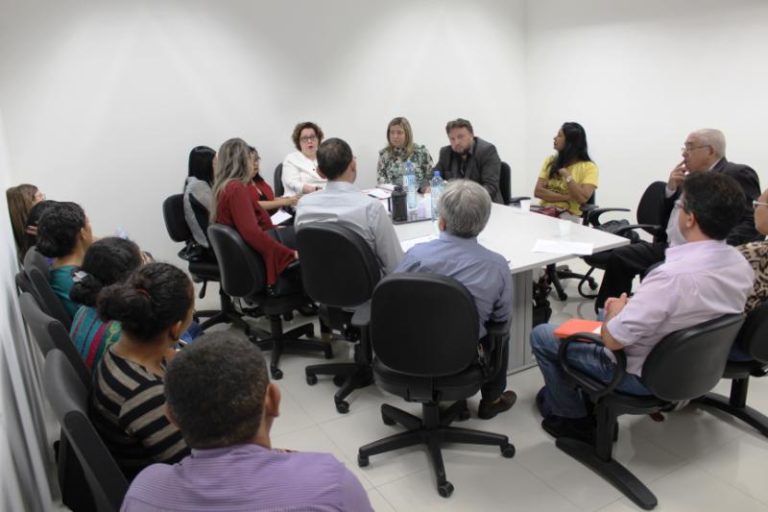 Pessoas sentadas em volta de uma mesa