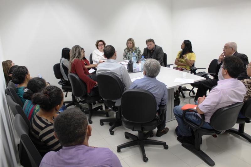 Pessoas sentadas em volta de uma mesa 