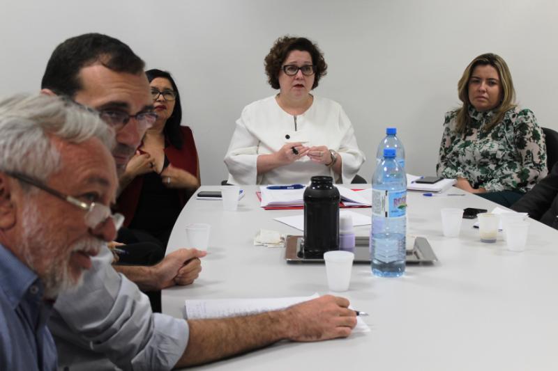 Pessoas sentadas em volta de uma mesa 