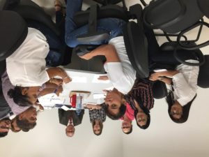 Pessoas sentadas em volta de uma mesa