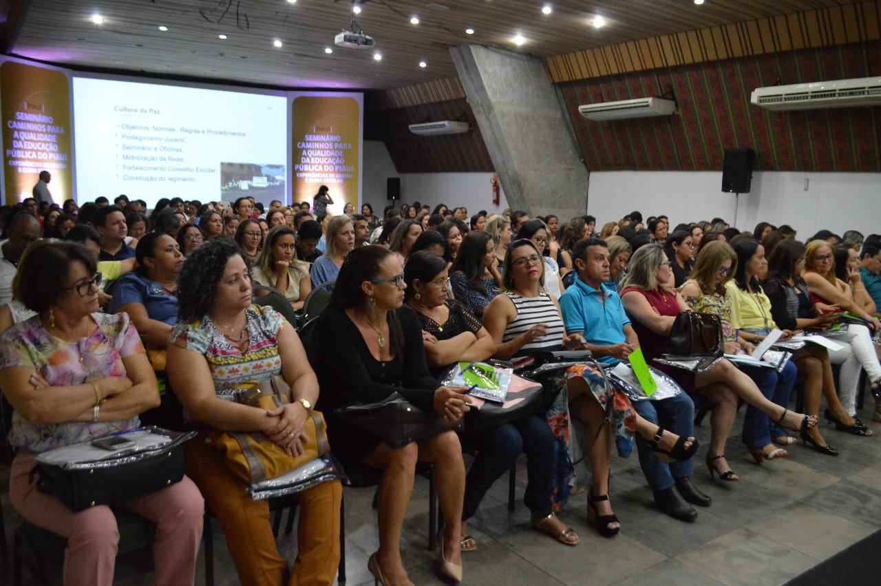 Pessoas sentadas em auditório 