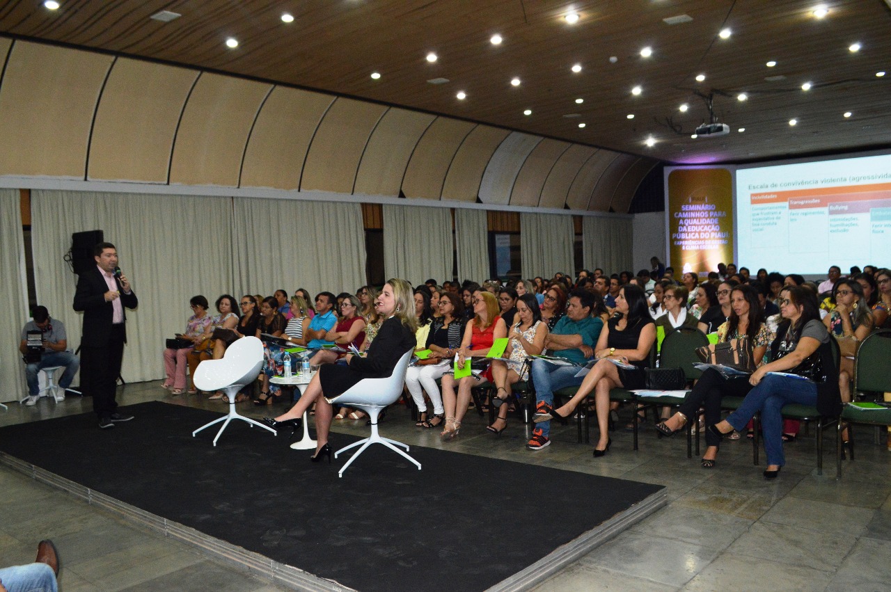 Pessoas sentadas em auditório 