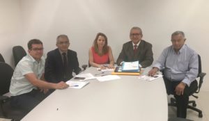 Pessoas sentadas em volta de uma mesa