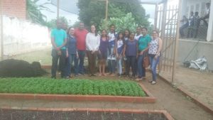 Promotora com alunos e professores em horta de escola