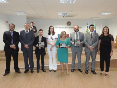 Pessoas sorrindo e posando com troféus