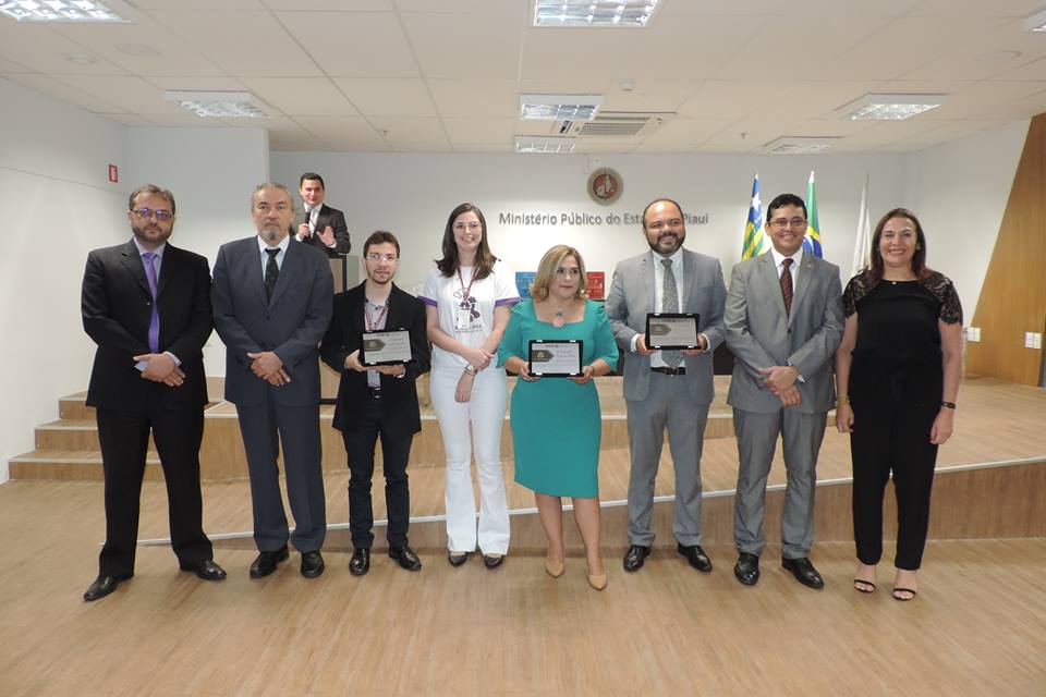Pessoas sorrindo e posando com troféus
