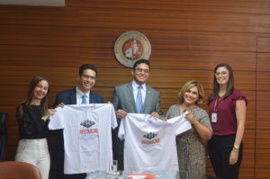 Equipes do MPPI e da SEJUS segurando camisas do projeto Reeducar