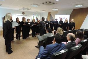 Pessoas de pé cantando em auditório