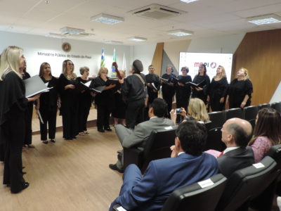 Pessoas de pé cantando em auditório