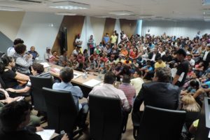 Pessoas sentadas em auditório durante audiência