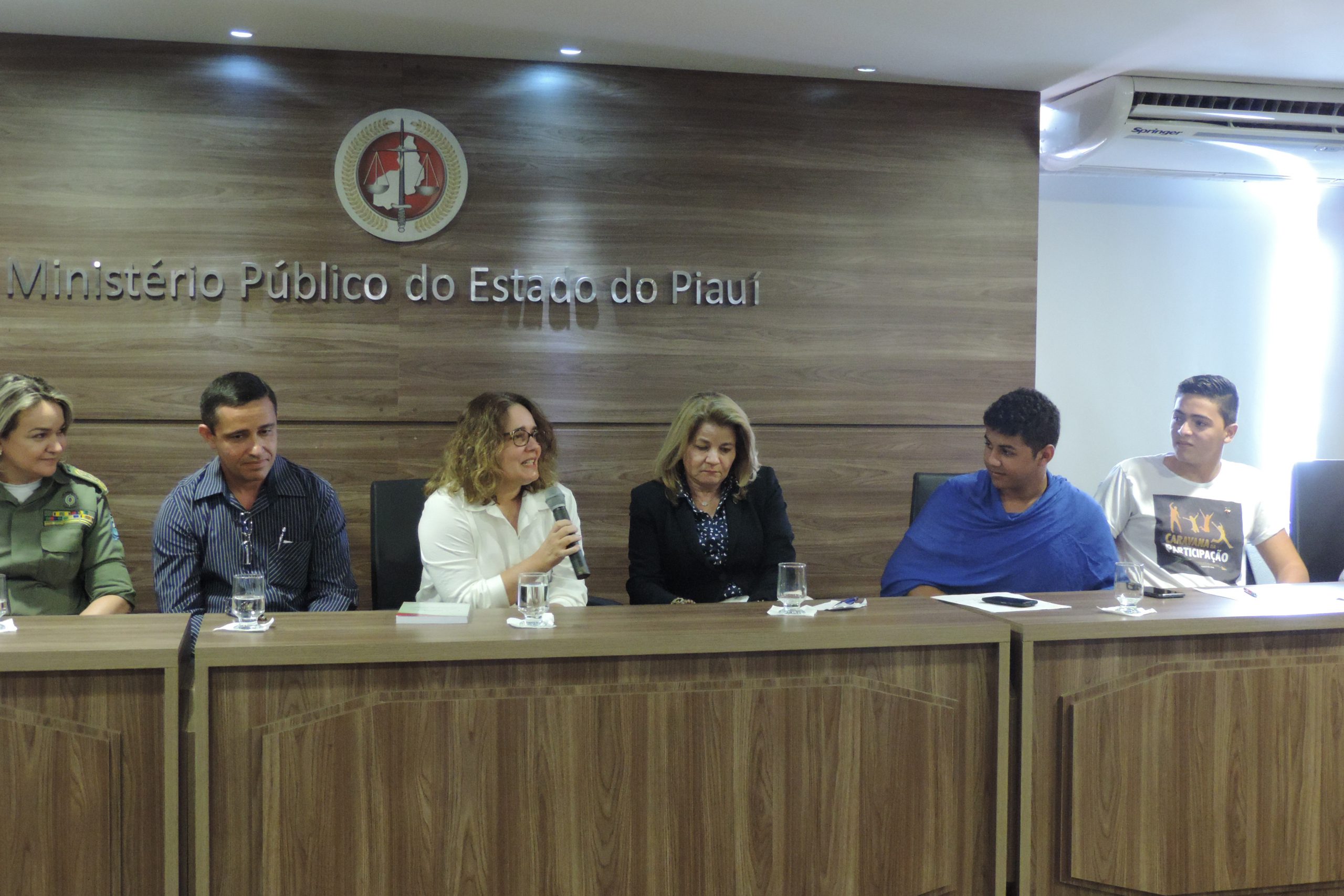 Pessoas sentadas na bancada do auditório 