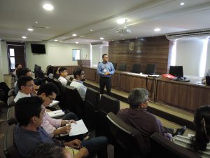 Pessoas sentadas observando pessoa de pé