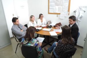 Pessoas sentadas em volta de uma mesa
