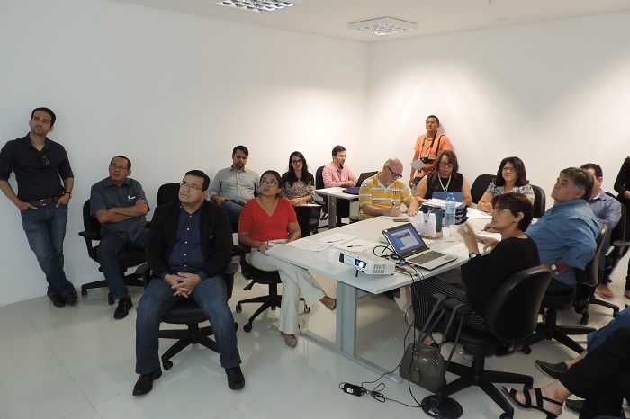 Pessoas sentadas em volta de uma mesa 