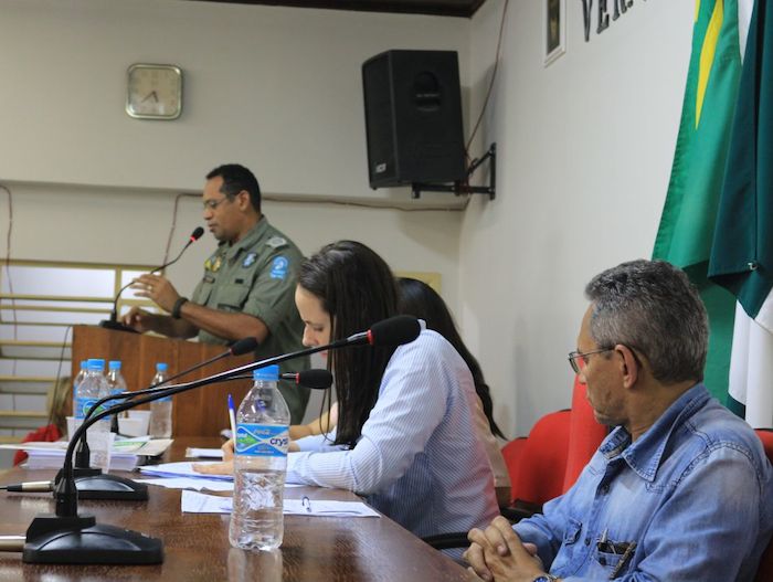 Pessoa falando à tribuna, para o público