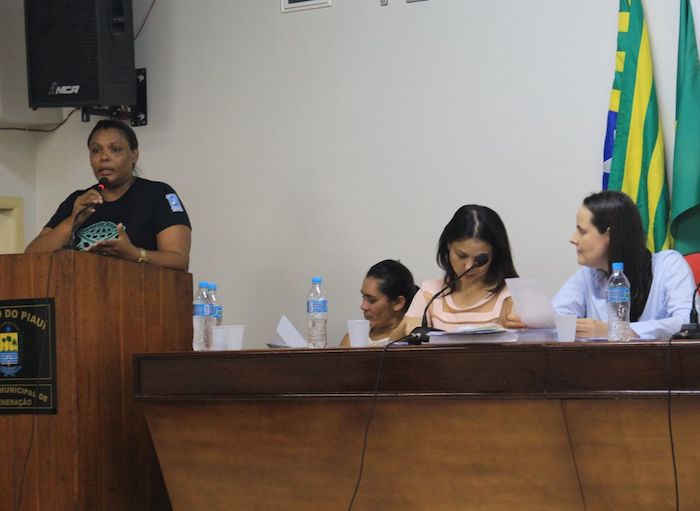 Pessoa falando à tribuna, para o público