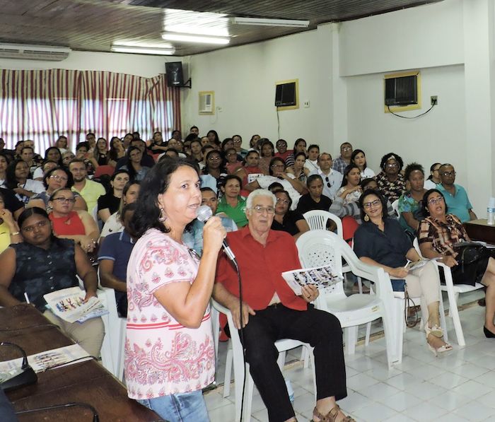 Pessoa falando à tribuna, para o público