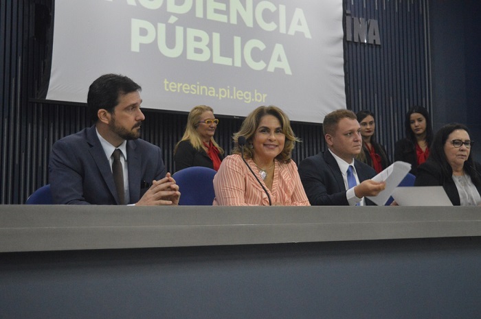 Pessoas sentadas atrás de uma bancada