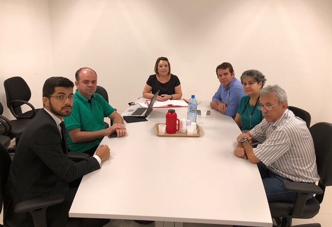 Pessoas sentadas em volta de uma mesa