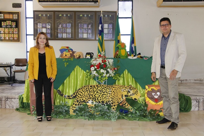 Duas pessoas de pé ao lado de animais 