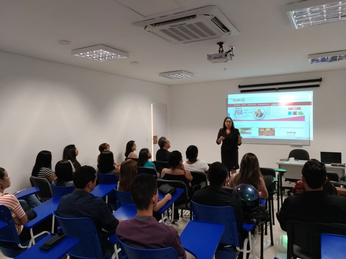 Pessoas sentadas em sala de aula observando seu interlocutor 