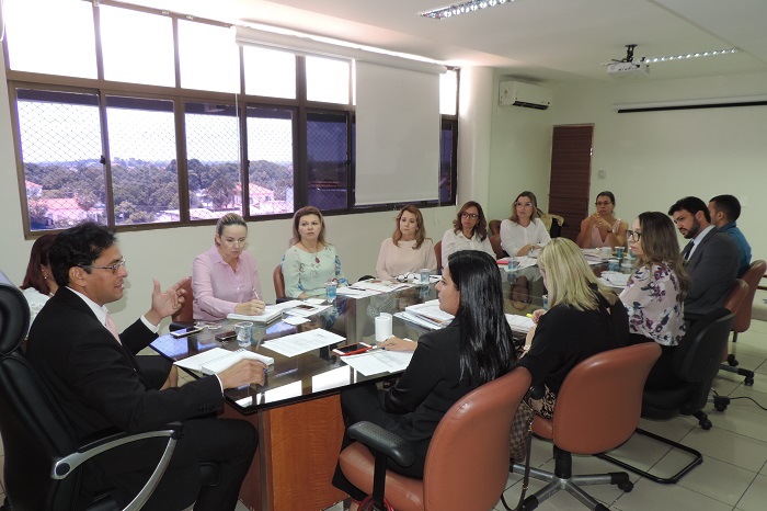 Pessoas sentadas em volta de uma mesa 