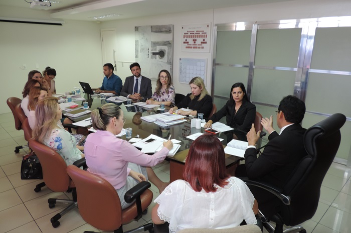 Pessoas sentadas em volta de uma mesa 