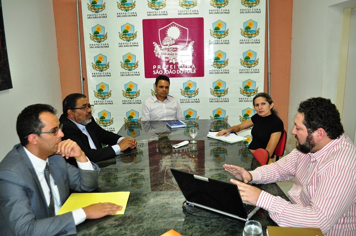Pessoas sentadas em uma mesa de reuniões 