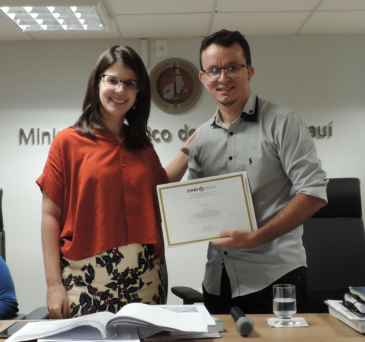 Duas pessoas segurando um certificado 