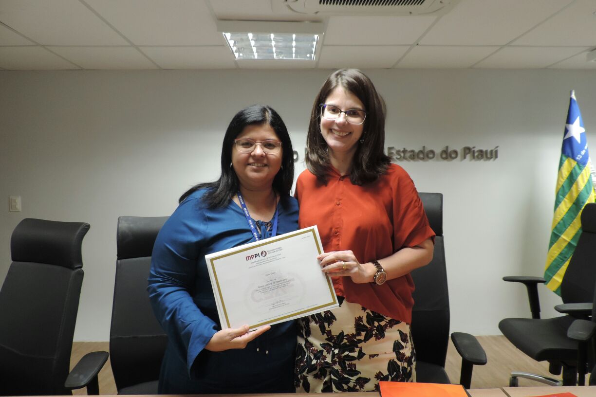 Duas pessoas segurando um certificados 