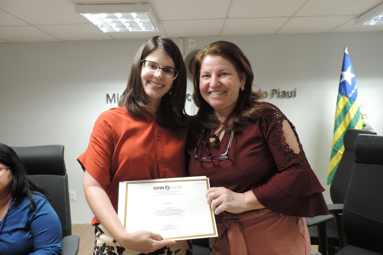 Duas pessoas de pé segurando um certificado 