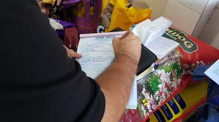 Mão de uma pessoas assinando um papel