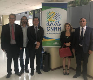Pessoas reunidas diantes de banner da reunião
