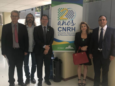 Pessoas reunidas diantes de banner da reunião