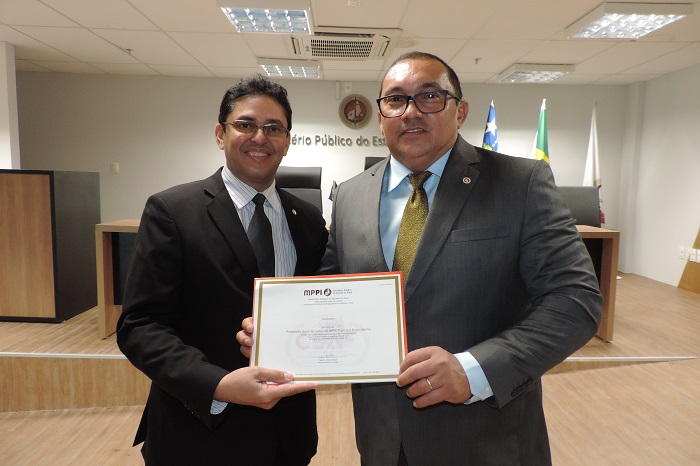 Duas pessoas segurando um documento e sorrindo 