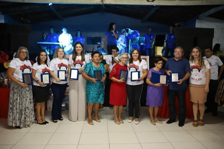 Pessoas de pé com placas de homenagem nas mãos