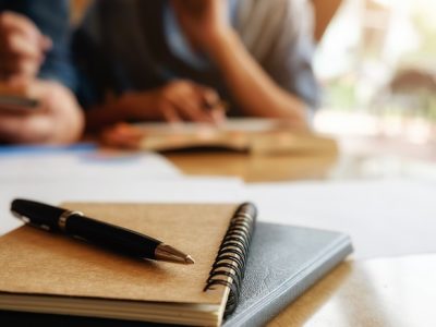 Foto de caderno e caneta sobre uma mesa